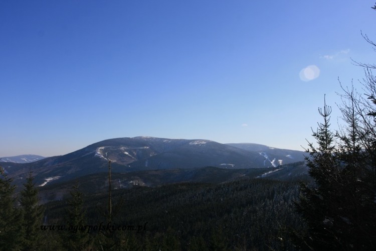 Po prawej Stoki narcierskie w Ramzovej. Po lewej Szerak 1351 m.n.p.m.<br />Góra położona jest na głównym europejskim dziale wodnym między zlewiskami Mórz: Bałtyckiego (dorzecze Odry) i Czarnego (dorzecze Dunaju